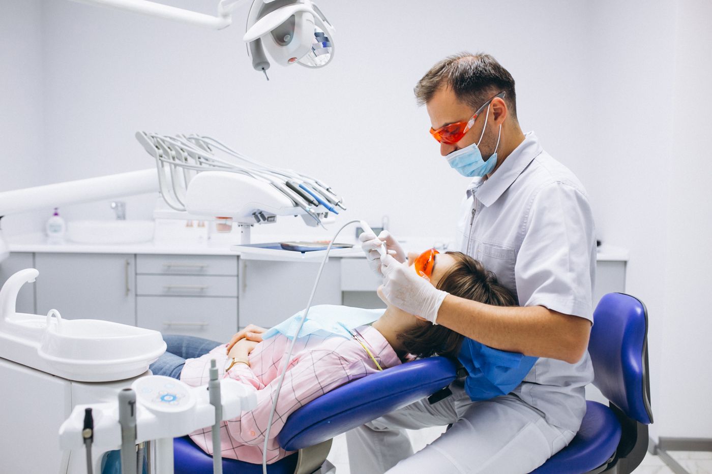 Dentista al lavoro con una paziente in uno studio odontoiatrico
